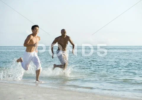 Two Men Running In Surf