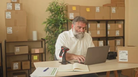 Two men scan and pack a cardboard box with hands visible, one holds a barco.. Stock Footage 339214390