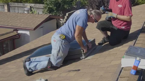 Two Men Screwing in a Large Skylight Window on a Rooftop Stock Footage 212417691