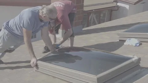 Two Men Screwing in a New Skylight Window on a Rooftop (RAW) Stock Footage 212418161