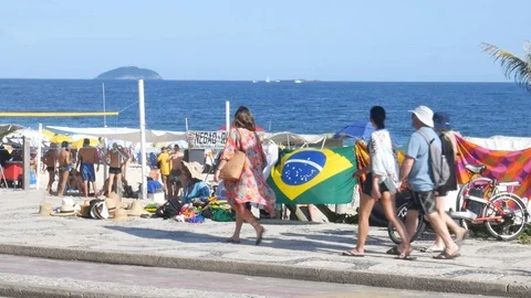 Two men sell hats and beach accessories to tourists at Rio de Janeiro's iconic Stock Footage 105185789