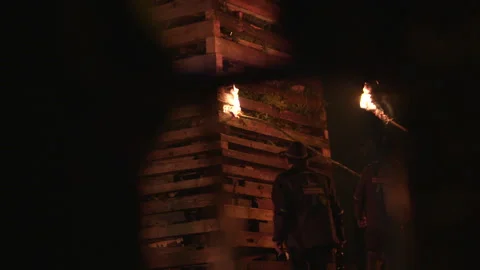 Two men setting fire to a wooden structure Stock Footage 267009969