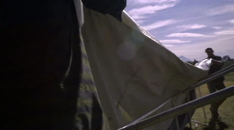 Two Men Setup Their Large Hunting Tent In Field Stock Footage