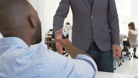 Two men shake hands before an interview in open plan office Stock Footage 78938969