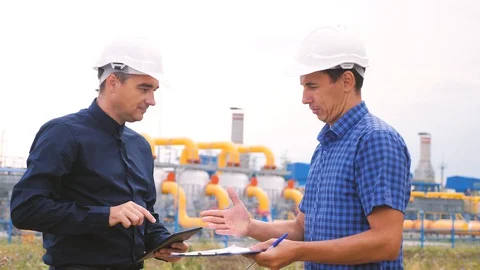 Two men shake hands working engineers work at a gas plant producing gas oil 스톡 동영상 129581831