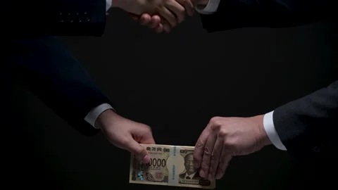 Two men shaking hands and passing new money as a bribe Stock Footage 336765850