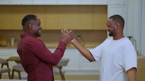 Two men share a fun event, dancing in kitchen, one with beard and facial hair Vidéo 267643628