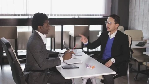 Two men sit in armchairs at the office and talking Stock Footage 81010476