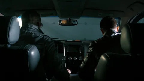 Two men sit in the car, standing in a spacious garage Stock Footage 105159599
