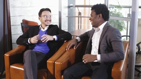 Two men sit at the office, talking and negotiate 스톡 동영상 80990332