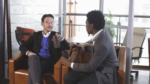 Two men sit at the office, talking and negotiate Stock Footage 83500069