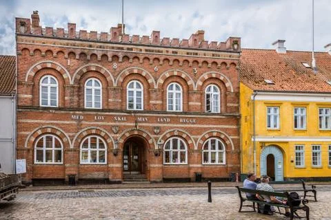 Two men sitting on a bench in front of the townhall in rskbing Stock Photos
