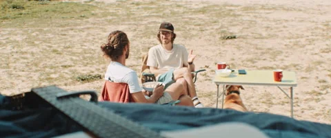 Two men sitting at a camp side table talking Stock Footage 203585123