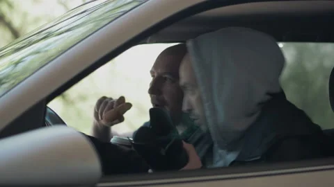 Two men sitting in a car and taking a picture with a professional camera, a Stock Footage 153483175