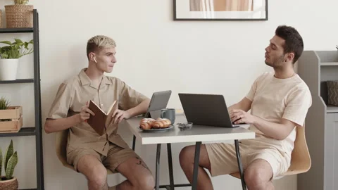 Two Men Sitting at Desktop and Chatting Stock Footage 153076130