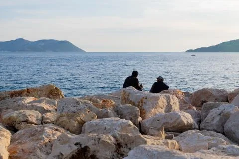 Two Men Sitting on the Rocks Stockfoto's