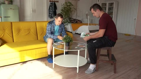 Two men sitting at a round table and counting money Video stock 161392256