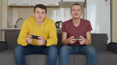 Two men smiling and play a video game with enthusiasm Stock Footage 107652462