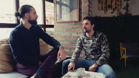 Two men smiling and talking in a cafe Stock Footage 95903585