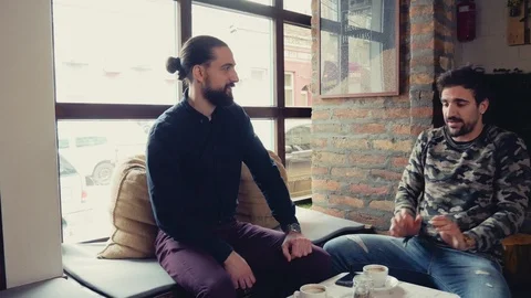 Two men smiling and talking while drinking coffee in cafeteria Stock Footage 95904952