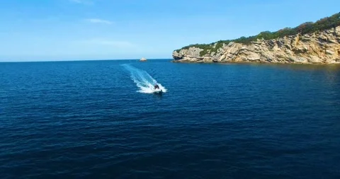 Two Men on a Speed Boat Comes Fastly on the Sea, 4k Drone Shot Stock Footage 149823519