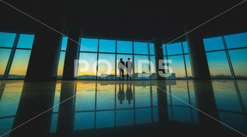 The two men stand on the panoramic window background Stock Photos