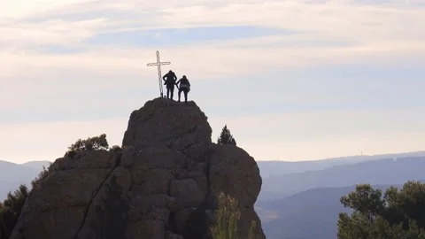 Two men stand on a rock next to the cross marking the ancient site of the Chapel Stock Footage 152080681