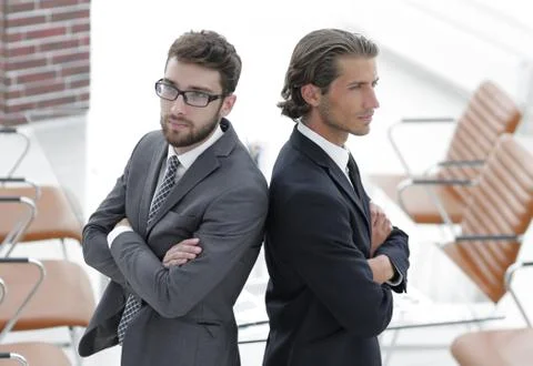Two men standing back to back and support each other Stock Photos