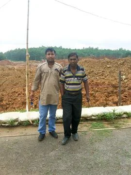 Two men standing in a construction site wearing a uniform. One is wearing a.. Stock Photos