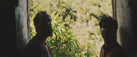 Two men standing in the doorframe looking into the building Stock Footage 202267020