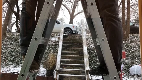 Two men standing on ladder in winter Stock Footage 124999854
