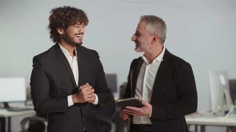 Two men standing in the office looking at something on a digital tablet. Two Stock Footage 256090504