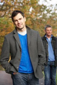 Two men standing outside in autumn woodland Stock Photos