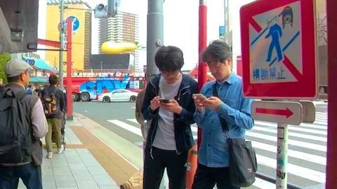 Two men standing on the side of the street in Osaka Japan Stock Footage 129279644