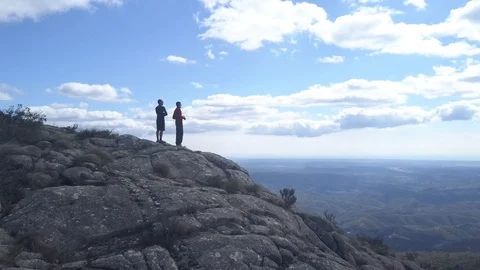 Two men standing on the top of a mountain with amazing views Stock Footage 98589477