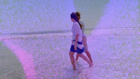 Two men stepping into surf, walking along shore for leisure travel, pink grain Stock Footage 331227094