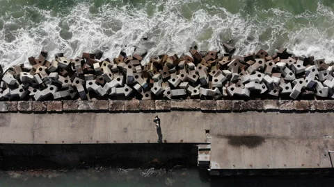 Two Men Stroll Along Pier as Waves Crash Against Concrete Pylons Below. Stock-Footage 137803805