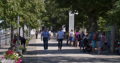 Two men strolling along a busy boulevard along the Rhine, Germany Stock Footage 113398190