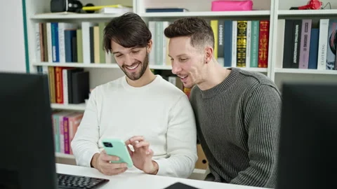 Two men students using computer and smartphone at library university Stock Footage 236757781