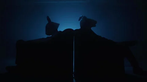 Two men in a suit with rabbit and goat masks sitting on the sofa in the club Stock-Footage 259017758