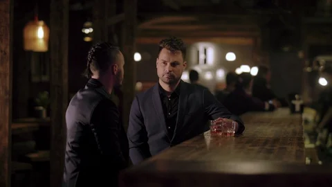 Two men in suits drink whiskey in a bar Stock Footage 105117553