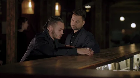 Two men in suits drink whiskey in a bar Stock Footage 105117911