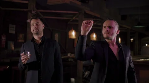 Two men in suits drink whiskey in a bar Stock Footage 105249257