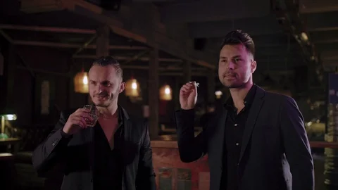 Two men in suits drink whiskey in a bar Stock Footage 105250874