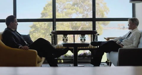 Two men in suits having a business meeting, they sitting near a big window on Stock Footage 146203094