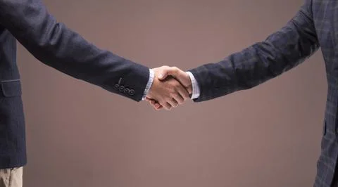 Two men in suits shake hands Stock Photos