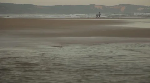 Two men in summer clothes walking along the beautiful beach (panorama). Stock Footage 42884577