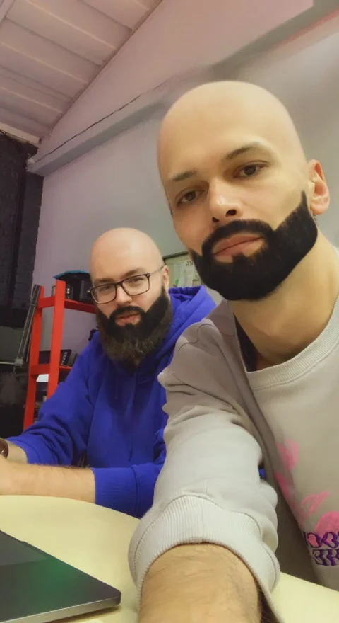 Two men take video selfies, adding augmented reality masks to their faces Stock Footage 234521493