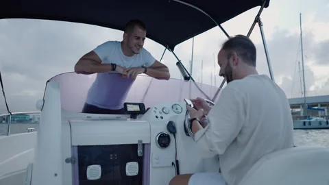 Two men talk on a boat about something on the phone Stock Footage 265909262