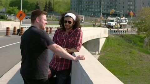 Two men talking on bridge - multicultural Stock Footage 67423799